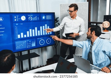 Presentation in office or meeting room with analyst team utilizing BI Fintech to analyze financial data. Businesspeople analyzing BI dashboard power display on TV screen for strategic planning.Prudent - Powered by Shutterstock