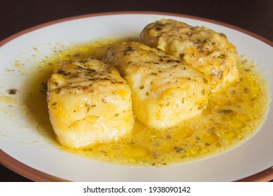 Presentation Of Three Tasty Hake Loins In Green Sauce On A White Plate. Fish And Healthy Food.