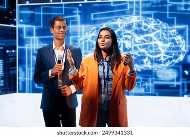 Presenter and guest chatting during AI summit discussion panel bringing together tech companies, exploring latest developments in artificial intelligence industry and emerging technologies - Powered by Shutterstock