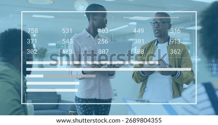 Presenters in casual attire analyzing data charts in office lounge, with laptop, tablet, documents. Collaboration, teamwork, modernoffice, dataanalysis, businessmeeting, professional, brainstorming