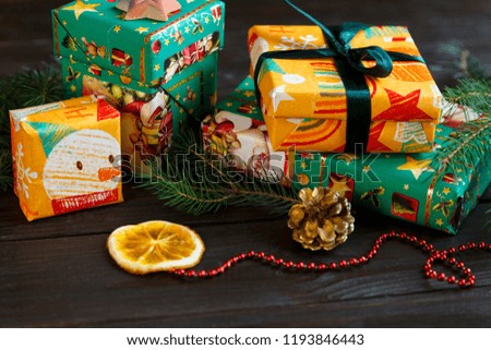 presents in orange and green paper on the wooden background  for friends and family. shopping,  New year and Christmas concept