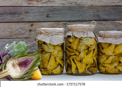 Preserved artichokes in olive oil in glass jars on wooden background. Autumn vegetables canning. Healthy homemade food - Powered by Shutterstock