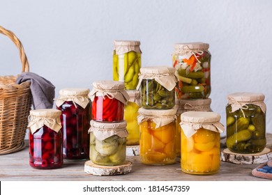 Preserved and fermented food. Assortment of homemade jars with variety of pickled and marinated vegetables, fruit compote on a wooden table. Housekeeping, home economics, harvest preservation  