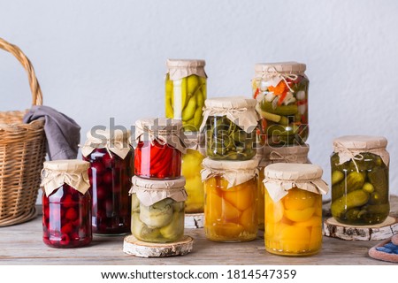 Preserved and fermented food. Assortment of homemade jars with variety of pickled and marinated vegetables, fruit compote on a wooden table. Housekeeping, home economics, harvest preservation  