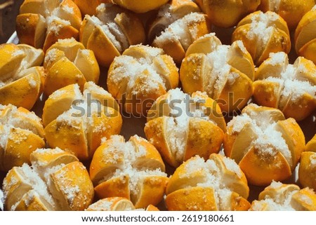 Preserved Lemons processing under sun. lime pickles in a plate, lime preserving process with salt, close up view taken from above, Preserving lime with salt, Preserved Lemons