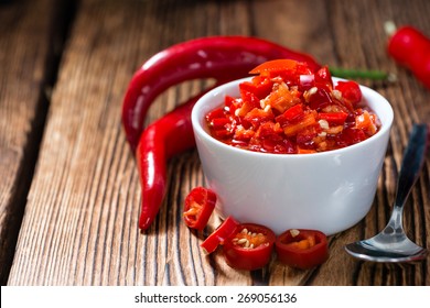 Preserved red Chilis (close-up shot) on wooden background