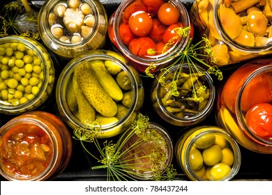 Preserves vegetables in glass jars in an old box. On the black chalkboard. - Shutterstock ID 784437244