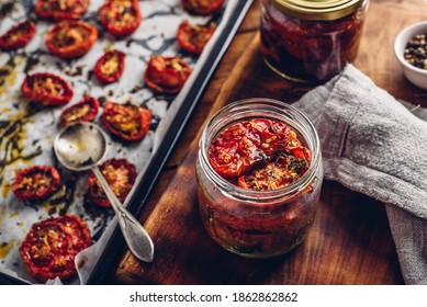 Preserving in Olive Oil of Sun Dried Tomatoes with Herbs in a Glass Jar