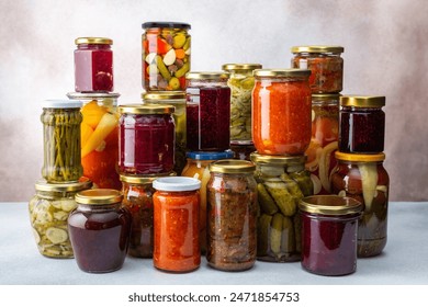 Preserving vegetables for the winter, a lot of glass jars with canned vegetables and adjika, jam and vegetable salads, pickled or fermented vegetables, copy space - Powered by Shutterstock