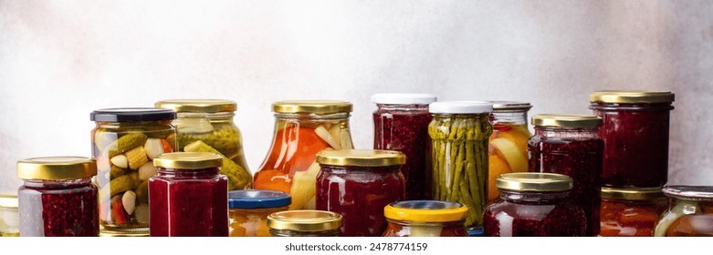 Preserving vegetables for the winter, a lot of glass jars with canned vegetables and adjika, jam and vegetable salads, pickled or fermented vegetables, banner - Powered by Shutterstock