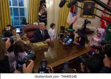 President Donald Trump poses for pictures with the children of White House journalists in the Oval Office, Friday, October 27, 2017.