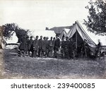 President Lincoln (1809-1865) on battle-field of Antietam with several officers outside tent.