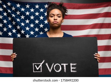 Presidential elections 2020 in USA. Black woman holding Vote sign against american flag