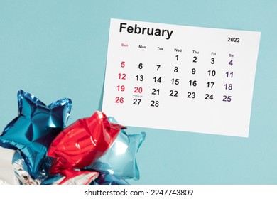 President's Day. Date on calendar February 20, 2023. Red, blue and white star balloon, decorations on blue background. Happy Presidents Day, calendar. Flat lay, top view, copy space