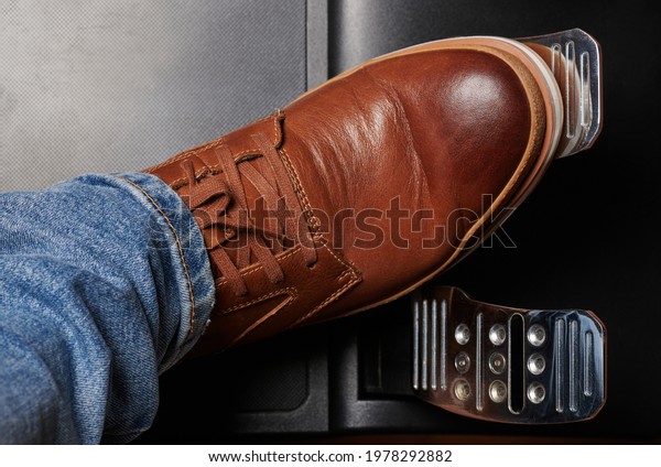 Press shiny metal car pedal  with brown leather\
shoes above top view