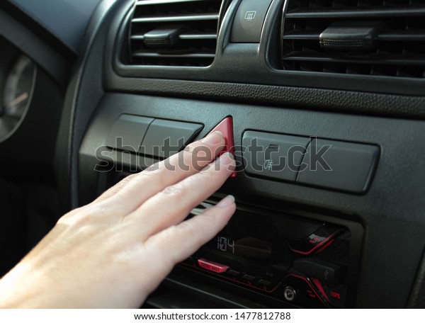 Presses\
the emergency button in the car with his\
fingers.