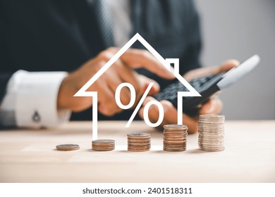 Pressing calculators, hand plans house refinance. Buy or rent, wooden house model on desk. Save for buying home concept, mortgage payment strategy. Tax, credit analysis for wise investment decision.