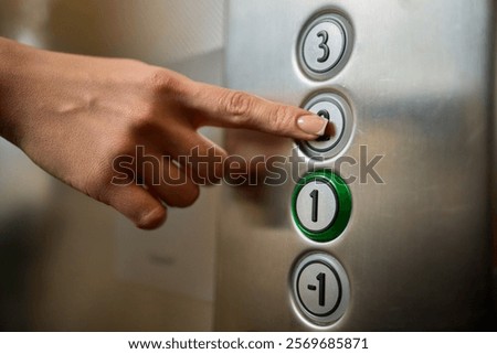 Pressing the elevator button in contemporary high rise buildings signifies modern urban convenience