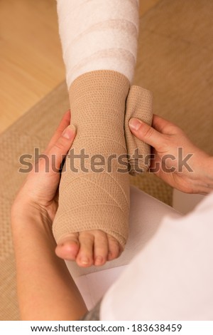 A pressure bandage is being applied by a nurse