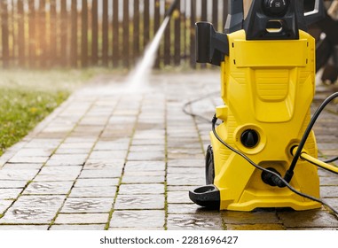 Pressure Cleaning with High Pressure Washer Karcher in Garden Park or Street. Cleaning Pavement Service concept.