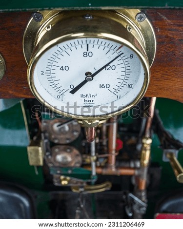 A pressure gauge dial on an old steam engine.