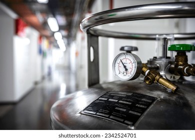 Pressure gauge equipment mounted on liquid nitrogen tank, chemical or pharmaceutical factory or plant workshop with metal industrial manufacturing production equipment