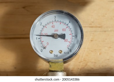 Pressure Gauge For Measuring The Pressure In The Water Supply System In The Apartment Close-up. The Pressure Gauge Measures Within 0..6 Bar. Two Scales On The Dial: In Bars And In Psi