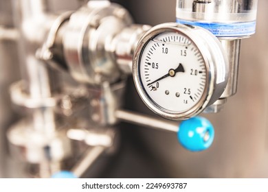 Pressure gauge on the pipe of craft brewing equipment in a brewery