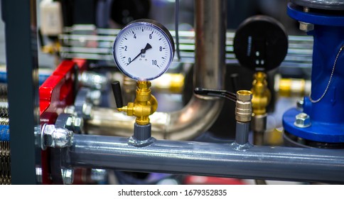 Pressure Gauge Psi Meter In Pipe And Valves Of Water System Industrial Focus Left Closeup White Light Defocus Blur Background.