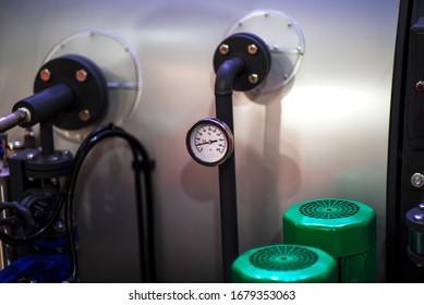 Pressure Gauge Psi Meter In Pipe And Valves Of Water System Industrial Focus Left Closeup White Light Defocus Blur Background.