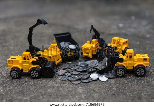 Pressure road\
car, Mechanical digger, Dump truck, Crane, Forklift, and Bulldozers\
toy work with pile of\
coins.