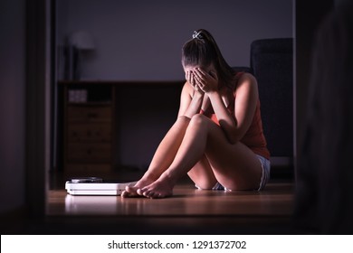 Pressure And Stress About Weight Loss, Diet Or Gaining Weight. Eating Disorder, Anorexia Or Bulimia Concept. Frustrated Woman Sitting On Floor With Scale. Unhealthy Body Image And Bad Self Esteem. 