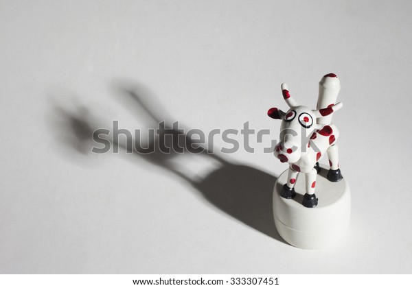 Pressure toy cow with articulated parts. Dramatic
lighting and shadow.