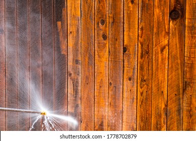 Pressure Washing Wooden Fence In Suburb Neighborhood During Stay At Home Orders For Covid-19 Lockdown Cleaning Surfaces And Home Repairs