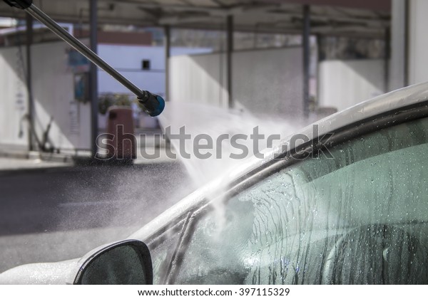 Pressure\
water jet over white car side window at car\
wash