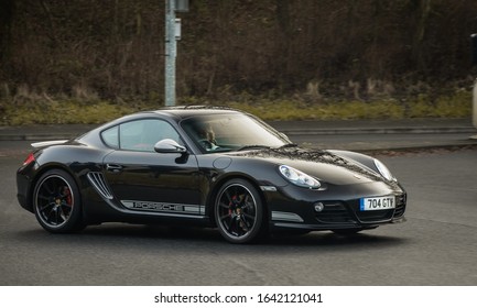 Preston, England, 19/01/2020 Porsche 911 Carrera in Black with white decals on the side, rich man driving his dream car with a lovely woman in the passenger seat enjoying their sports car speed