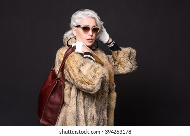 Pret-a-Porter or High Fashion. Portrait of old model posing for Roberto Cavalli project in studio. Beautiful lady resembling actress from Devil wears Prada.