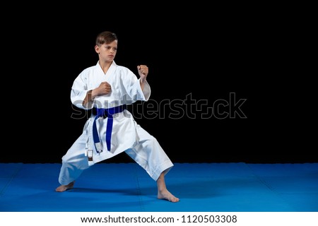 Pre-teen boy doing karate on a black background