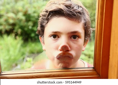 Preteen Boy Grimace Flat Press Nose And Lips Against Window Glass