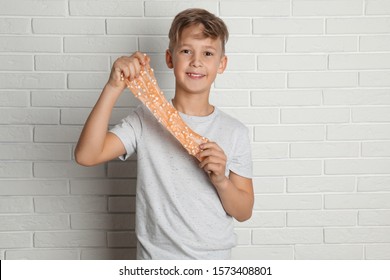 Preteen Boy With Slime Near White Brick Wall