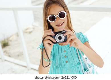 Preteen child resting and taking photos at the beach in summer