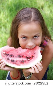 Preteen Girl Eats Fresh Watermellon On Green Grass Background