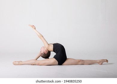 preteen girl gymnast trains on white background in black leotard. children's professional sports. rhythmic gymnastics.  - Powered by Shutterstock