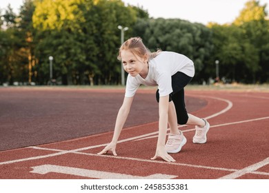 Pre-teen girl ready to race on an athletics track. Child girl on the starting line ready to run. Children sport, accomplishment , healthy active lifestyle concept. - Powered by Shutterstock