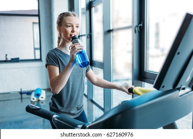 Preteen Girl Training On Treadmill And Drinking Water In Fitness Class. Gym Class Kids Concept