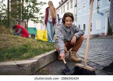 Preteen Girl Volunteer With Team Cleaning Up Street, Community Service Concept