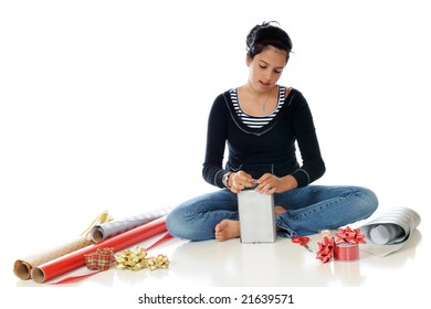 Preteen Girl Wrapping A Gift For Christmas.  Isolated On White.