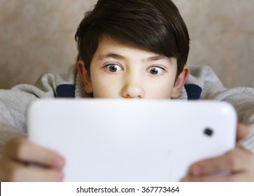 Preteen Handsome Boy With Bad Gaming Habit Play Computer Game On His Tablet Close Up Portrait