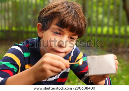 preteen handsome boy play with box of matches