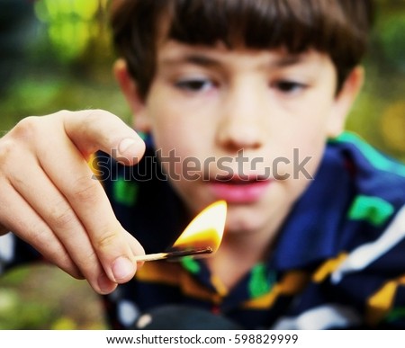 preteen handsome boy play with fire hold match